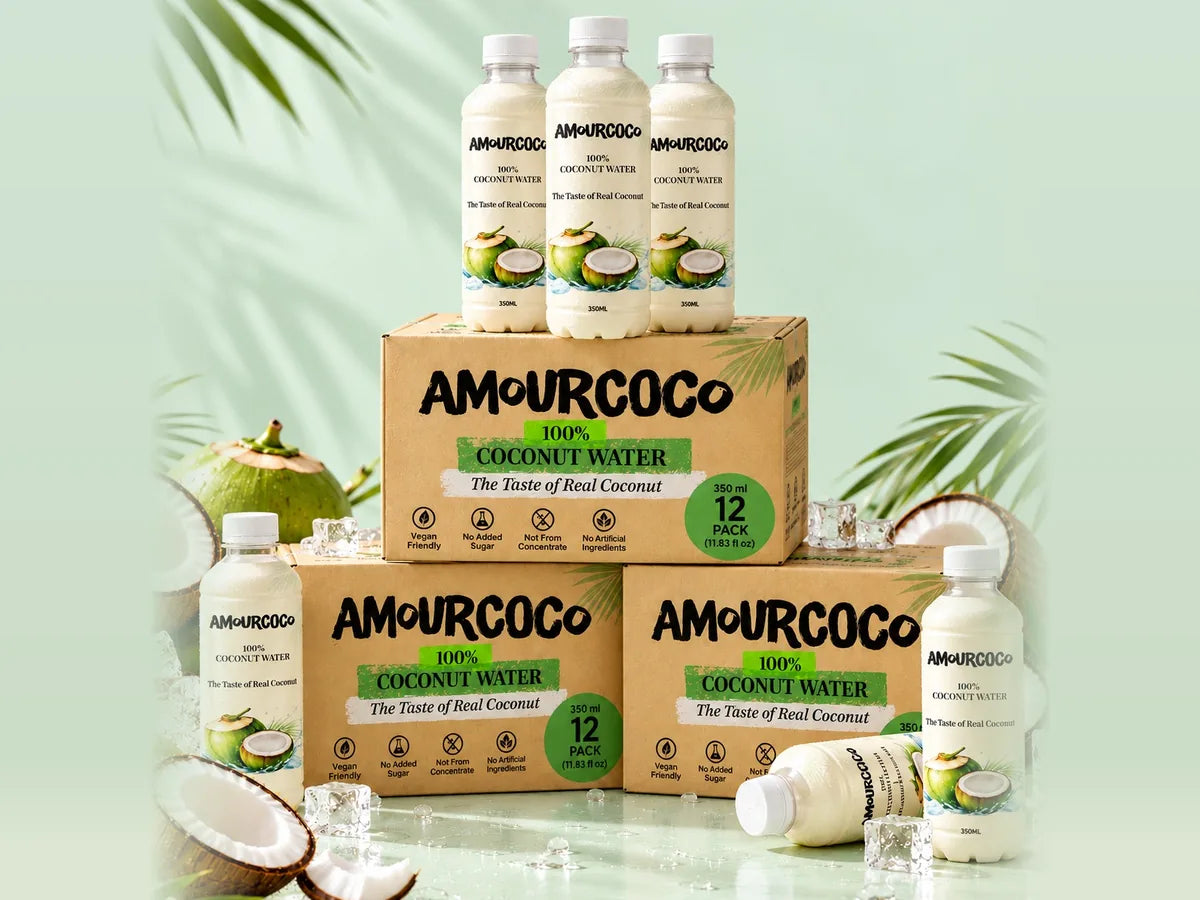 AmourCoco 100% coconut water bottles and 12-pack boxes with fresh coconuts, palm leaves and ice